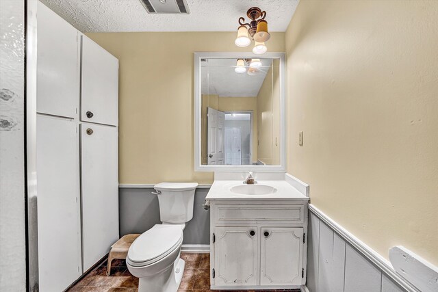 spare room with a textured ceiling, wood walls, baseboards, ceiling fan, and wood finished floors