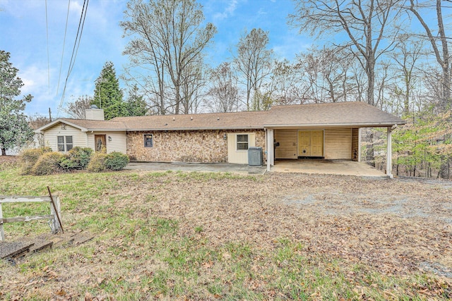 rear view of house featuring an attached carport, a chimney, and central air condition unit
