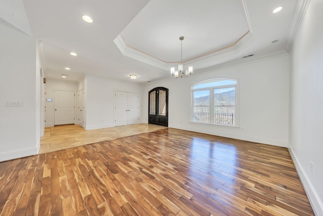 7425 Willow Leaf Cir, Roanoke, VA 24018 - spare room featuring a chandelier, light wood-style floors, ornamental molding, a raised ceiling, and baseboards