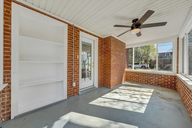 unfurnished sunroom featuring a ceiling fan