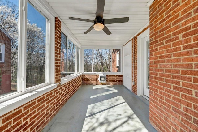 unfurnished sunroom with ceiling fan