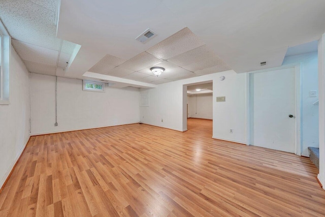 interior space featuring visible vents, light wood finished floors, and a drop ceiling