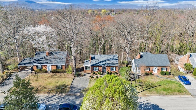drone / aerial view with a wooded view and a mountain view