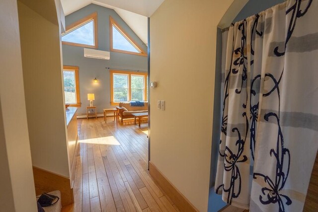 475 Loss Bent Rd NW, Riner, VA 24149 - hallway with a wall mounted air conditioner, light wood-type flooring, baseboard heating, vaulted ceiling, and baseboards