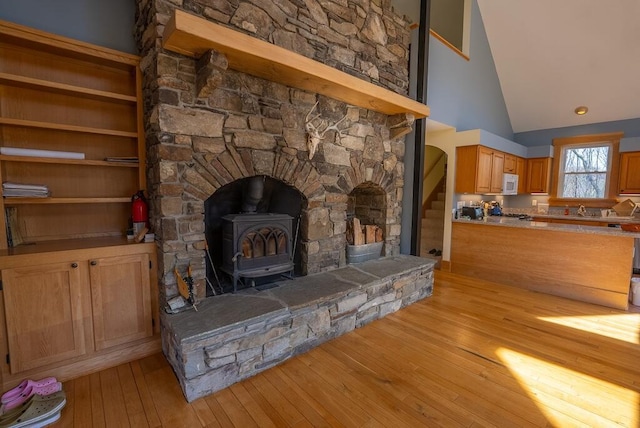 475 Loss Bent Rd NW, Riner, VA 24149 - unfurnished living room with a wood stove, light wood finished floors, high vaulted ceiling, and a sink