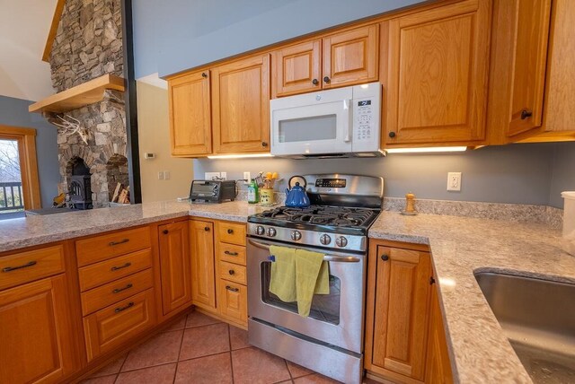 475 Loss Bent Rd NW, Riner, VA 24149 - kitchen with gas stove, white microwave, light tile patterned floors, a fireplace, and a sink