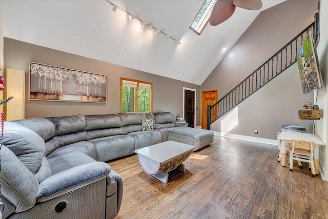 living room featuring a ceiling fan, wood finished floors, track lighting, baseboards, and stairs