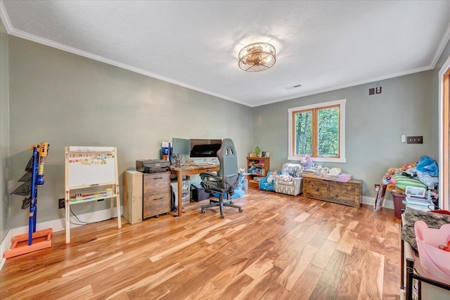 home office with light wood-style floors, baseboards, and crown molding