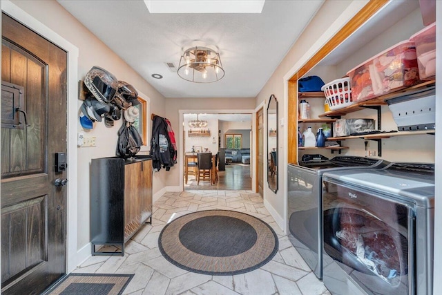 clothes washing area with washing machine and clothes dryer, baseboards, and laundry area