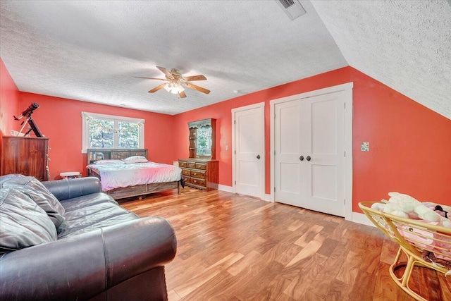 bedroom featuring light wood finished floors, a textured ceiling, and visible vents