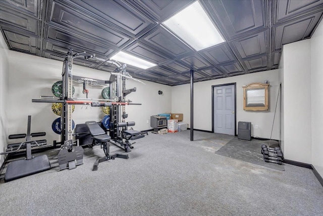 workout area featuring baseboards, an ornate ceiling, and carpet