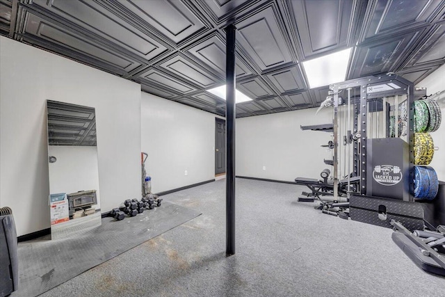 workout room with baseboards, an ornate ceiling, and carpet