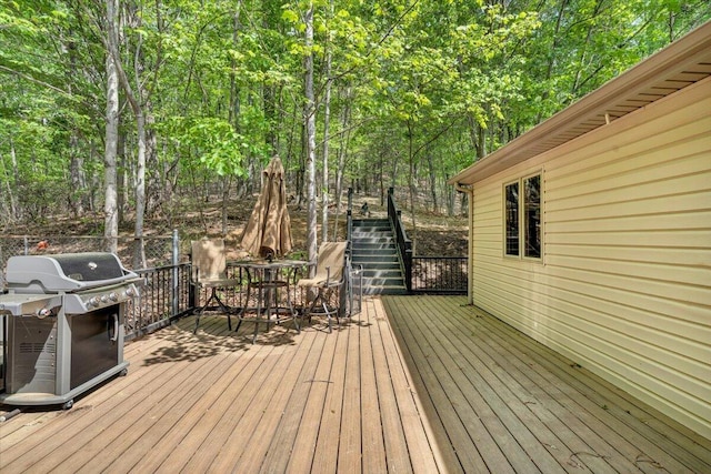 wooden terrace featuring grilling area and outdoor dining space