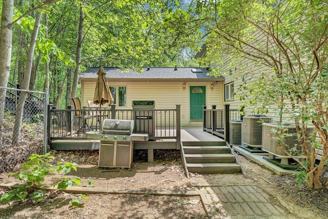 back of property with central AC and a deck