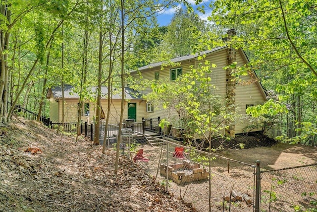 rear view of property with fence, a chimney, and a deck