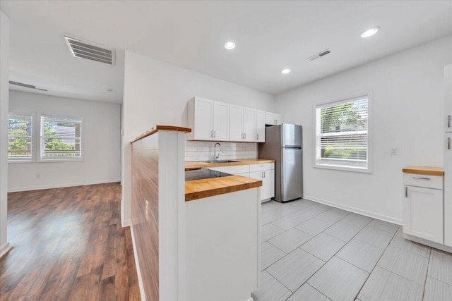 1113 17th St SE, Roanoke, VA 24013 - kitchen with a sink, wooden counters, freestanding refrigerator, decorative backsplash, and visible vents