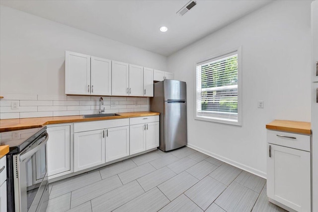 1113 17th St SE, Roanoke, VA 24013 - kitchen with a sink, wooden counters, stainless steel appliances, backsplash, and visible vents