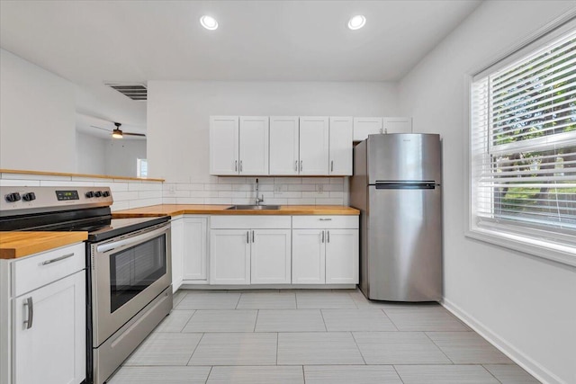 1113 17th St SE, Roanoke, VA 24013 - kitchen with appliances with stainless steel finishes, a sink, decorative backsplash, and butcher block counters