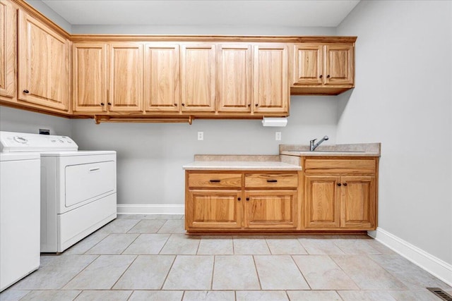 laundry area featuring baseboards, washing machine and clothes dryer, a sink, visible vents, and cabinet space