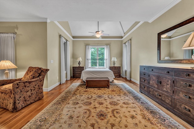 bedroom featuring crown molding, lofted ceiling, baseboards, light wood finished floors, and ceiling fan