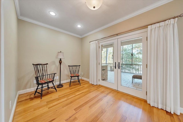 living area featuring baseboards, wood finished floors, french doors, and crown molding