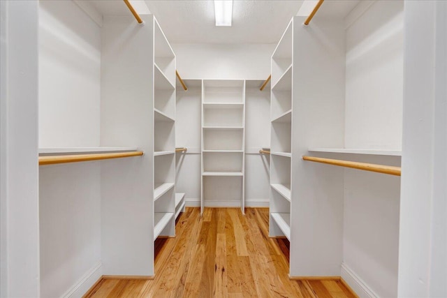 walk in closet with wood finished floors