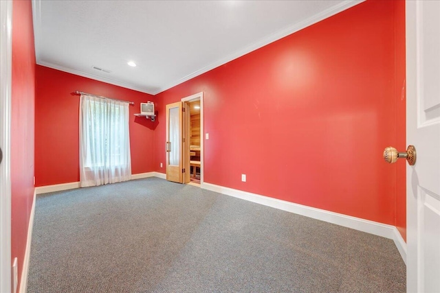 empty room featuring a wall unit AC, crown molding, carpet, baseboards, and visible vents