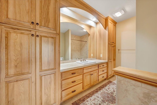 bathroom with tile patterned flooring, a shower, and vanity