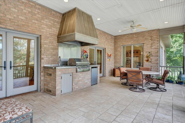 view of patio featuring french doors, grilling area, outdoor dining space, ceiling fan, and an outdoor kitchen