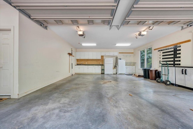 garage featuring baseboards, a garage door opener, and freestanding refrigerator