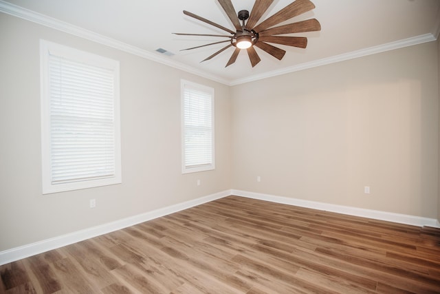 spare room with ceiling fan, visible vents, crown molding, and wood finished floors