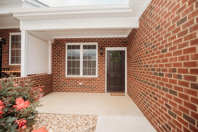 doorway to property featuring brick siding