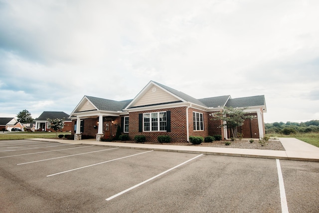 exterior space featuring brick siding and uncovered parking