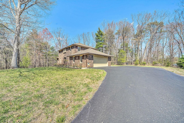 view of front facade featuring an attached garage, aphalt driveway, a front lawn, and brick siding