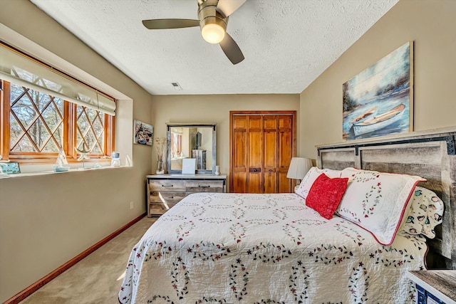 bedroom featuring a closet, a textured ceiling, visible vents, carpet, and baseboards