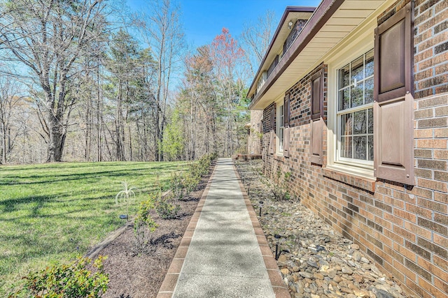view of property exterior featuring a lawn and brick siding