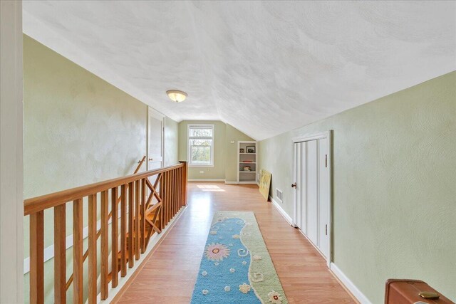 721 Mount Vernon Ave, Salem, VA 24153 - hallway featuring vaulted ceiling, an upstairs landing, a textured ceiling, light wood-style floors, and a textured wall