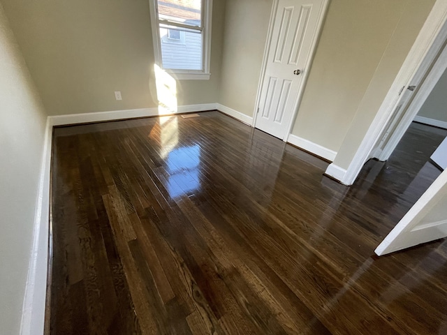 unfurnished bedroom featuring baseboards and dark wood finished floors