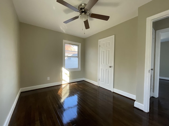 unfurnished bedroom with a ceiling fan, dark wood-style flooring, and baseboards