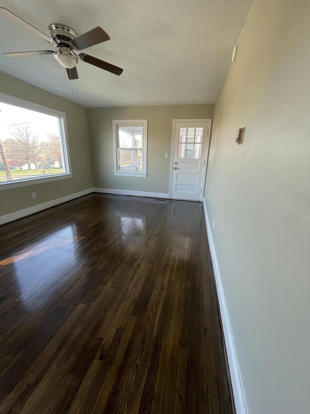 interior space featuring dark wood finished floors, baseboards, and ceiling fan