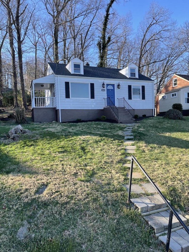view of front of property featuring a front lawn and roof with shingles