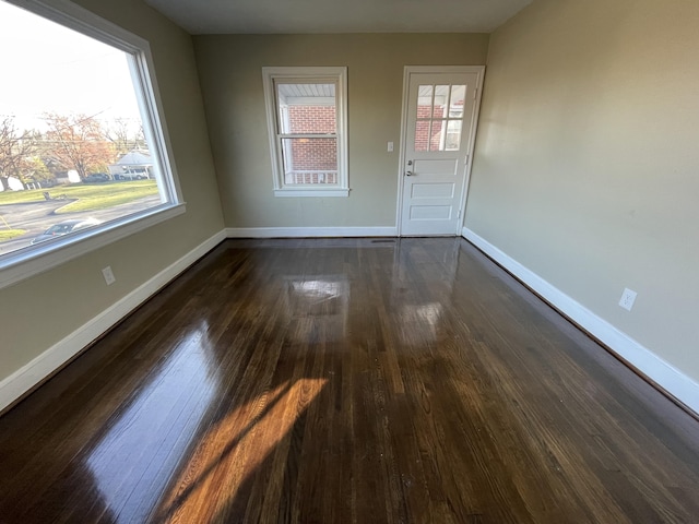 interior space with dark wood-style flooring and baseboards