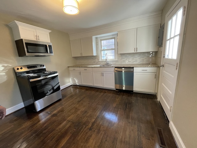 kitchen with white cabinetry, dark wood-type flooring, a sink, visible vents, and appliances with stainless steel finishes
