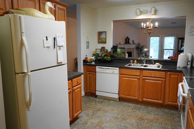 kitchen with white appliances, a notable chandelier, brown cabinetry, and a sink