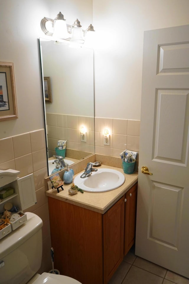 bathroom with tile walls, tile patterned floors, toilet, and vanity