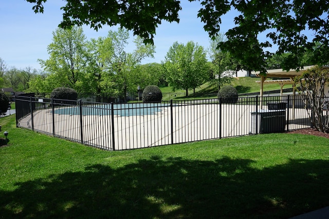 pool with a yard and fence