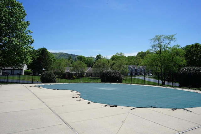 community pool with fence and a patio area