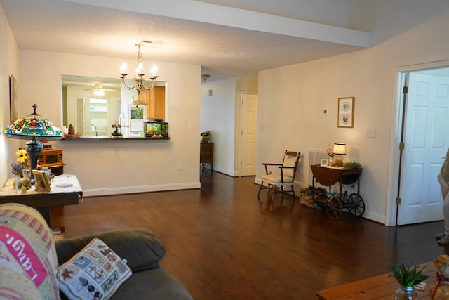 living room featuring dark wood-type flooring, ceiling fan with notable chandelier, and baseboards