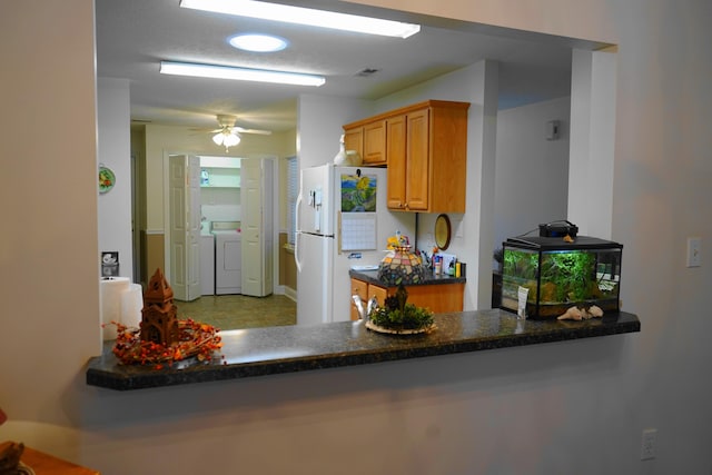 kitchen featuring separate washer and dryer, freestanding refrigerator, dark countertops, visible vents, and a ceiling fan