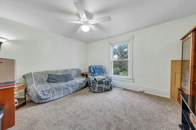 living area featuring a ceiling fan and carpet